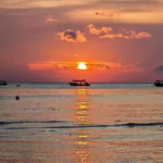 Enchanting Tioman Sea Sunset Long Sunrays Reflecting on the Water with a Boat Silhouette